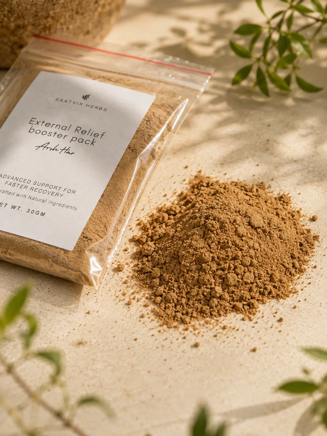 The booster pack beside a small heap of the pale brown powder poured out onto stone, with leaf shadows across it