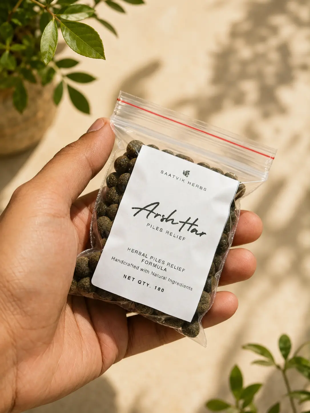A hand holding the ArshHar tablet pouch in sunlight, with a potted plant behind